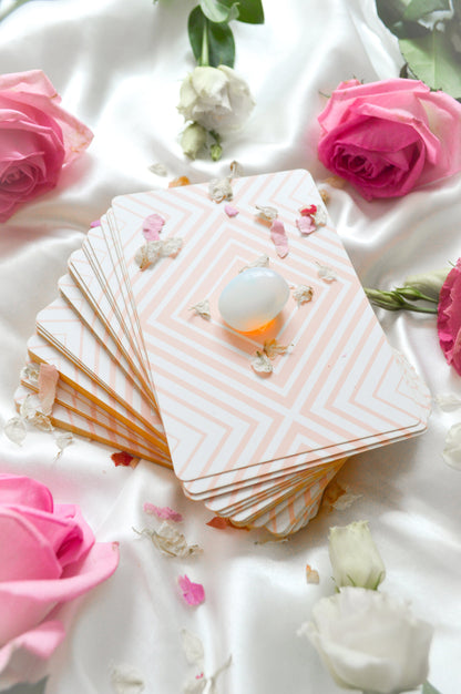 Tarot deck with tarot cards fanned out and shimmering gold edges and roses with crystal